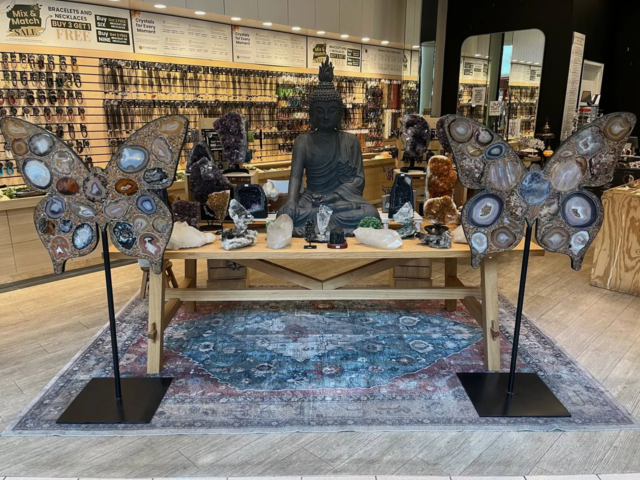 The Altamonte Mall store, a seated stone figure flanked by agate wing displays against a full wall of product
